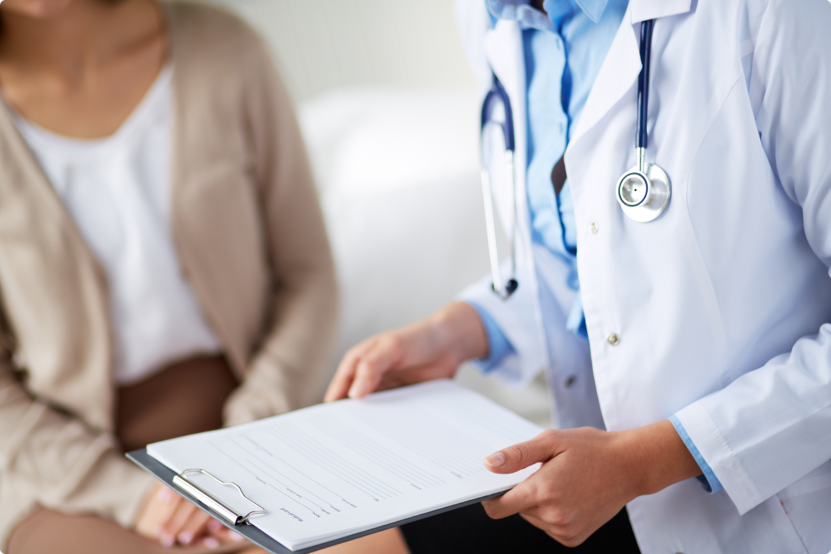 Medico specialista con camice che illustra il referto a una paziente