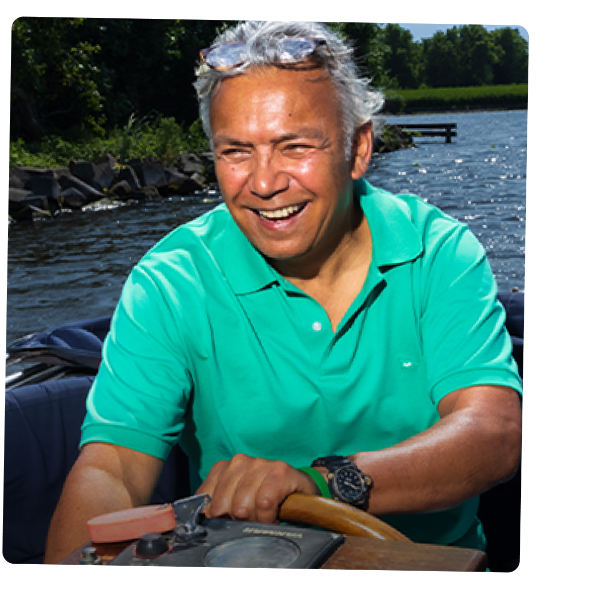 Een man bestuurt een kleine motorboot op een rivier.